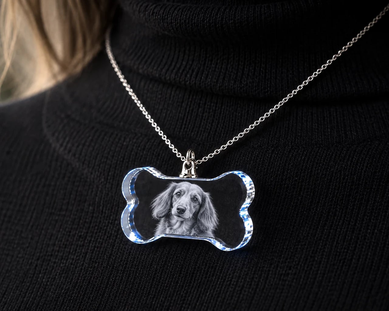 Bone crystal necklace with a spaniel portrait worn over a black sweater